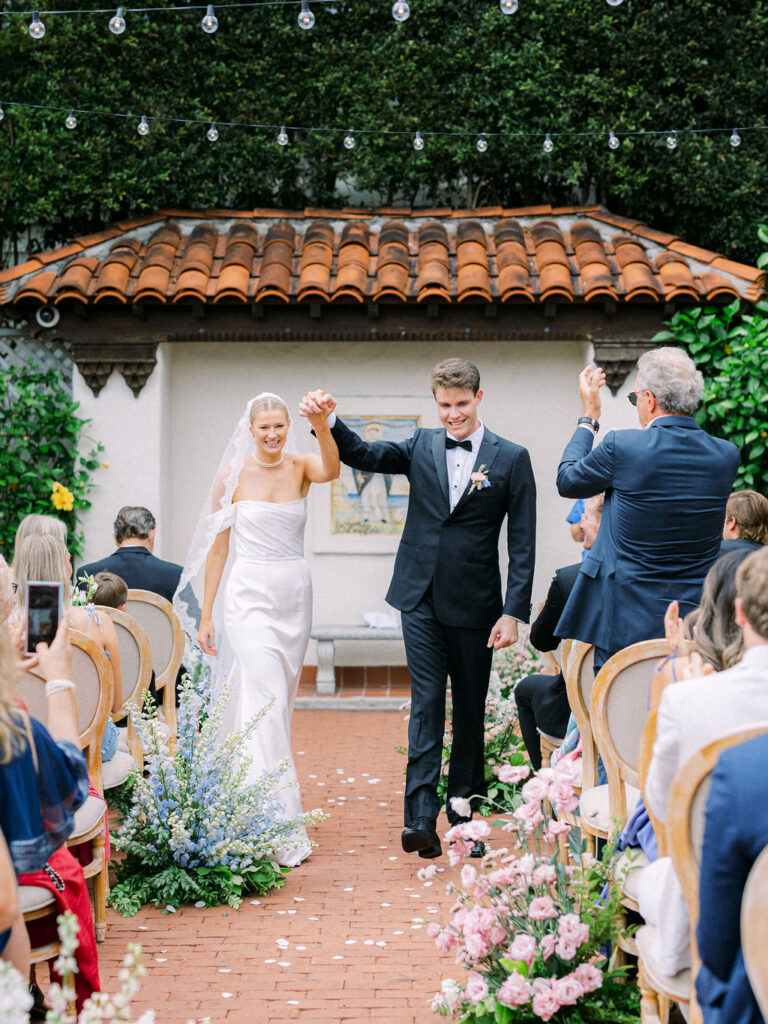 Bride and groom walking down the aisle in the Rose Garden at the Darlington House