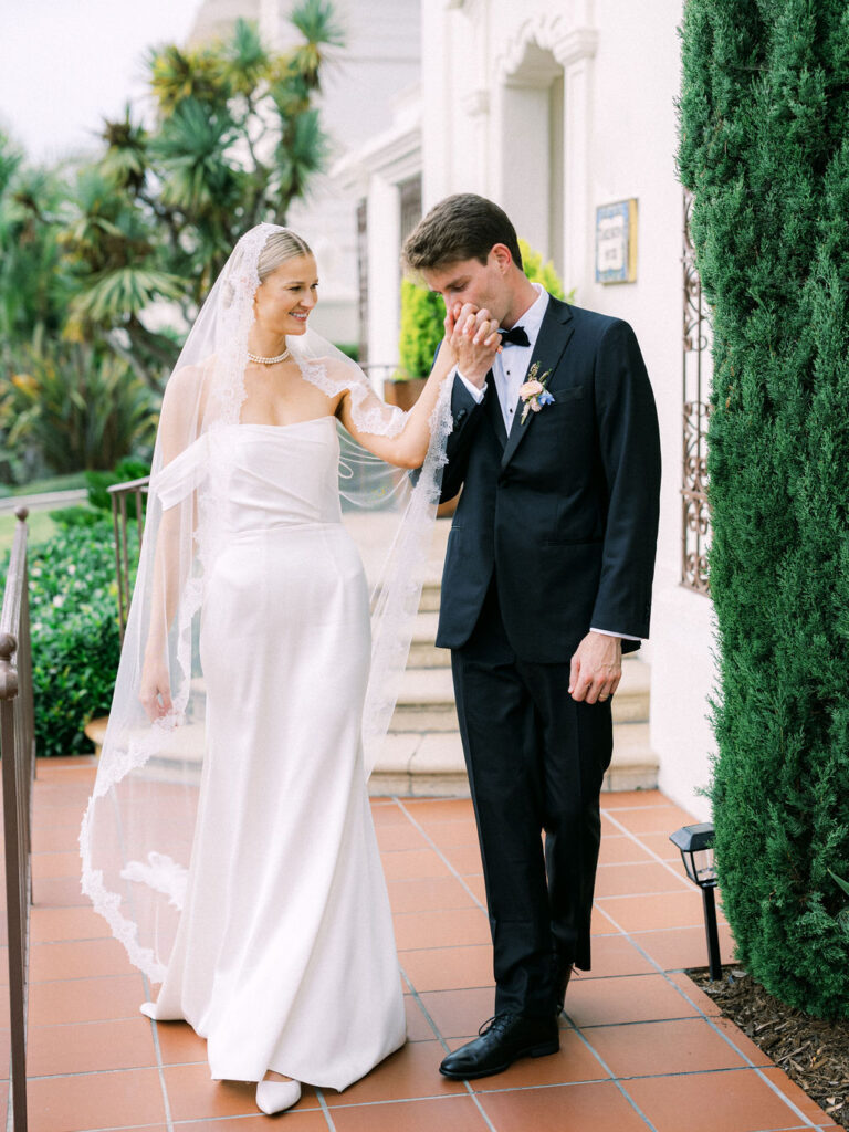 Groom kissing bride's hand