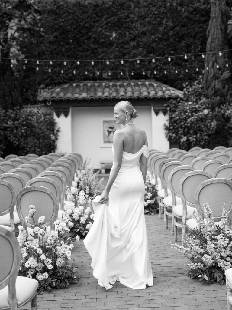 Black and white photo of a bride at her ceremony in the Rose Garden of the Darlington House