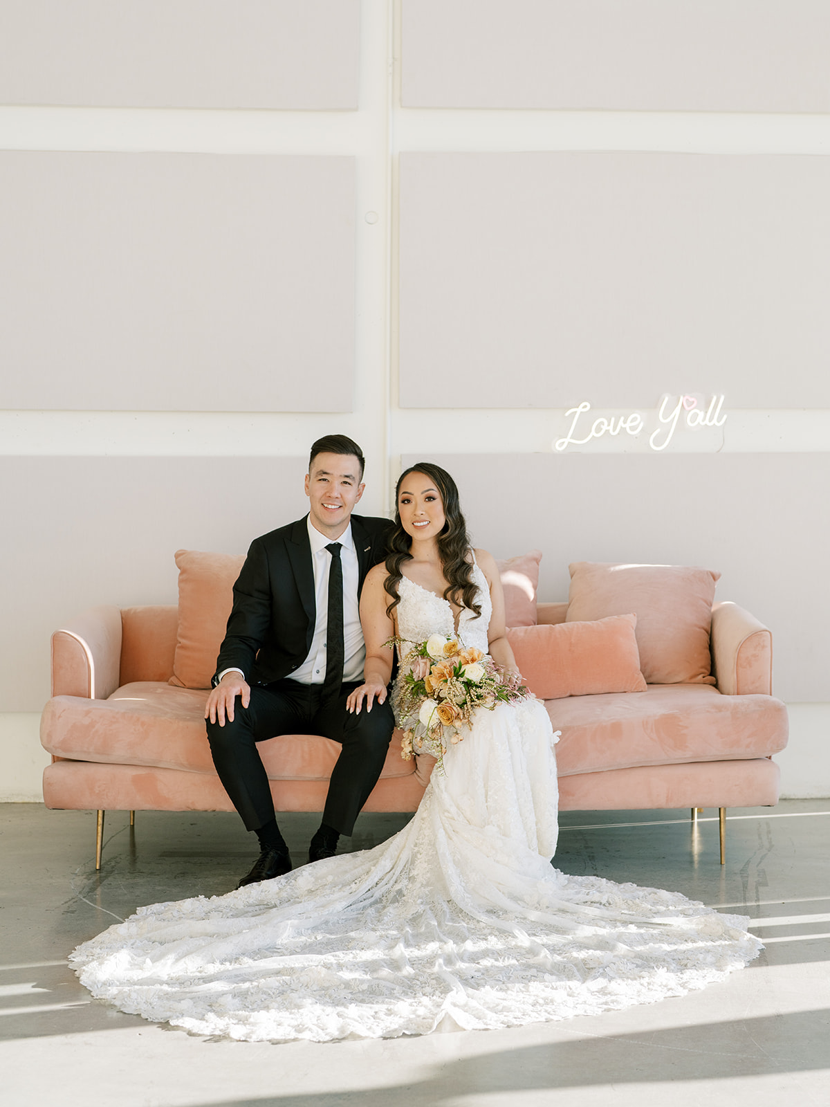 bride and groom sitting on a pink couch at the Lane