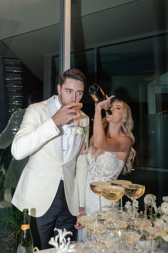 bride drinking from a bottle of champagne at Scripps Seaside Forum