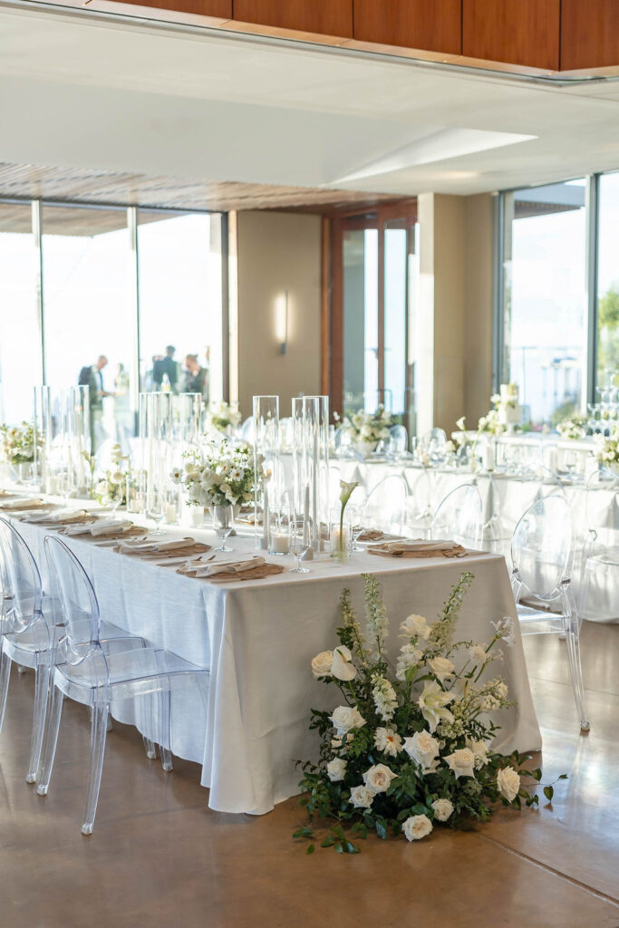 White linen and ghost chairs at wedding reception at Scripps Seaside Forum