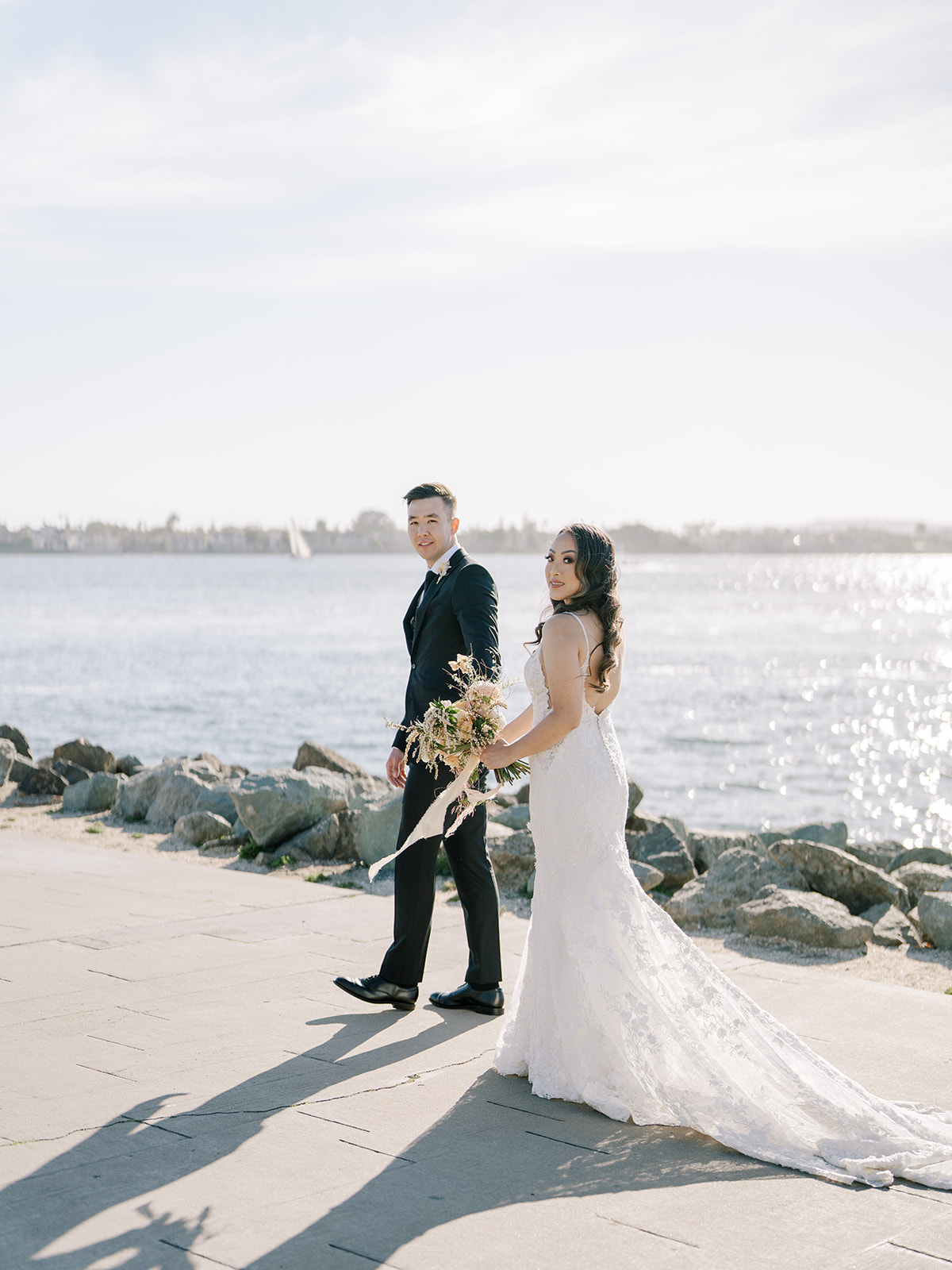 Bride and groom walking by the ocean in San Diego