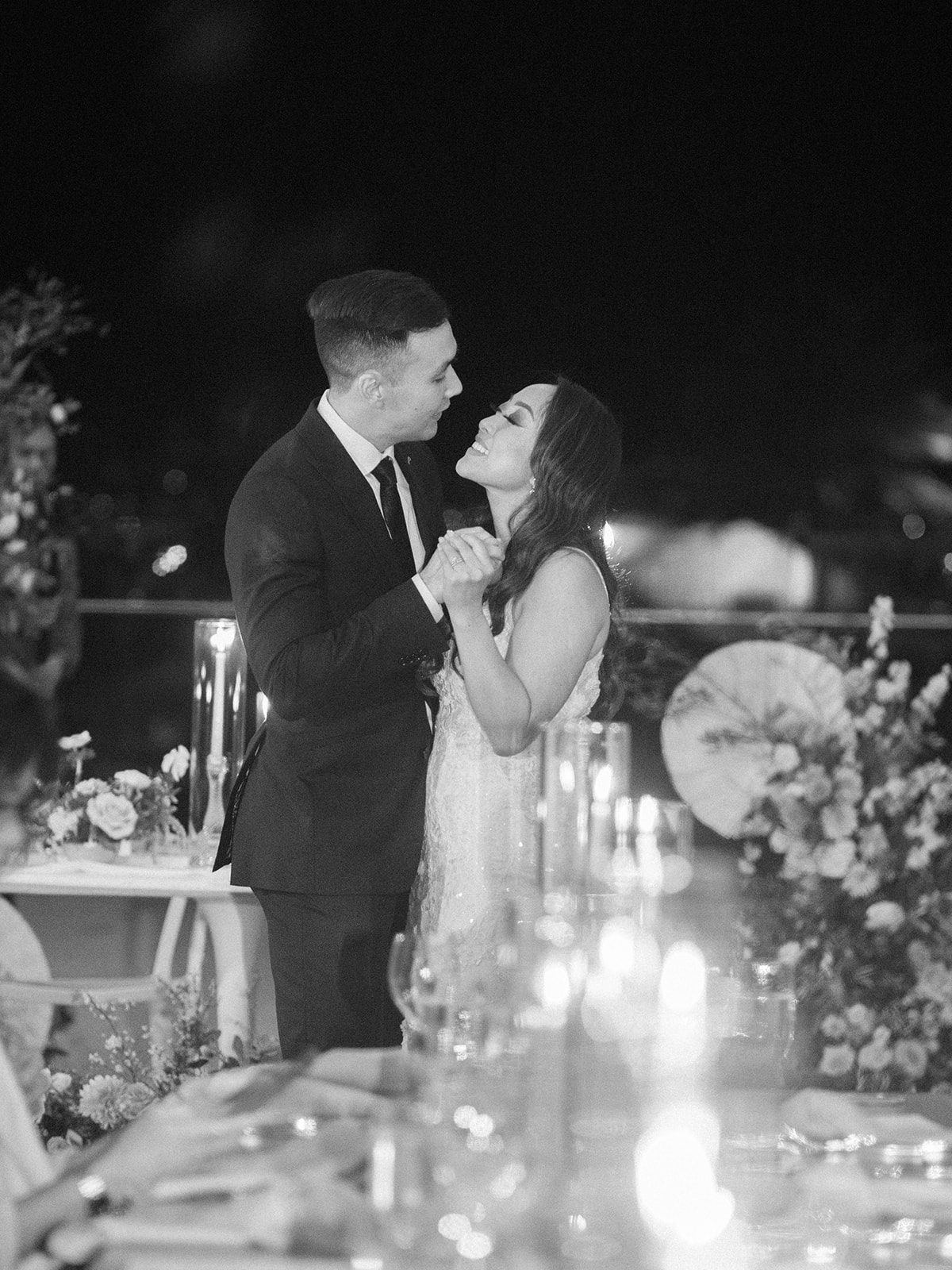 black and white of bride and groom kissing